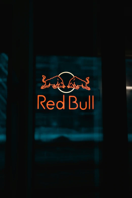 the red bull sign lit up in the dark