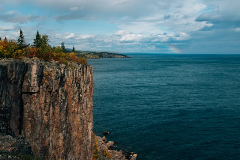 a person sits alone on top of a rocky outcropping