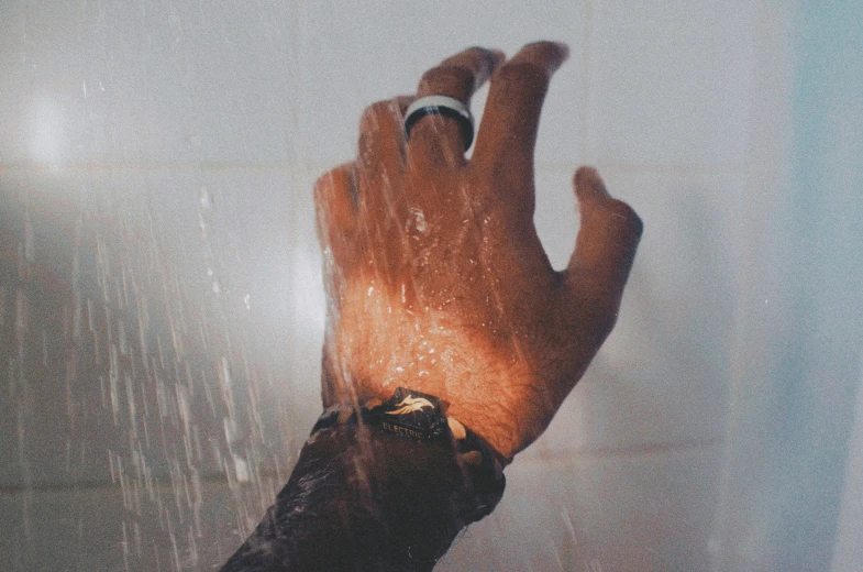 a hand holding a cell phone in front of a window