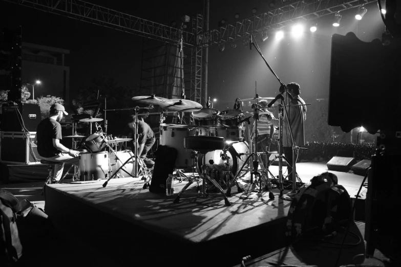 drummers are playing on the stage for an audience