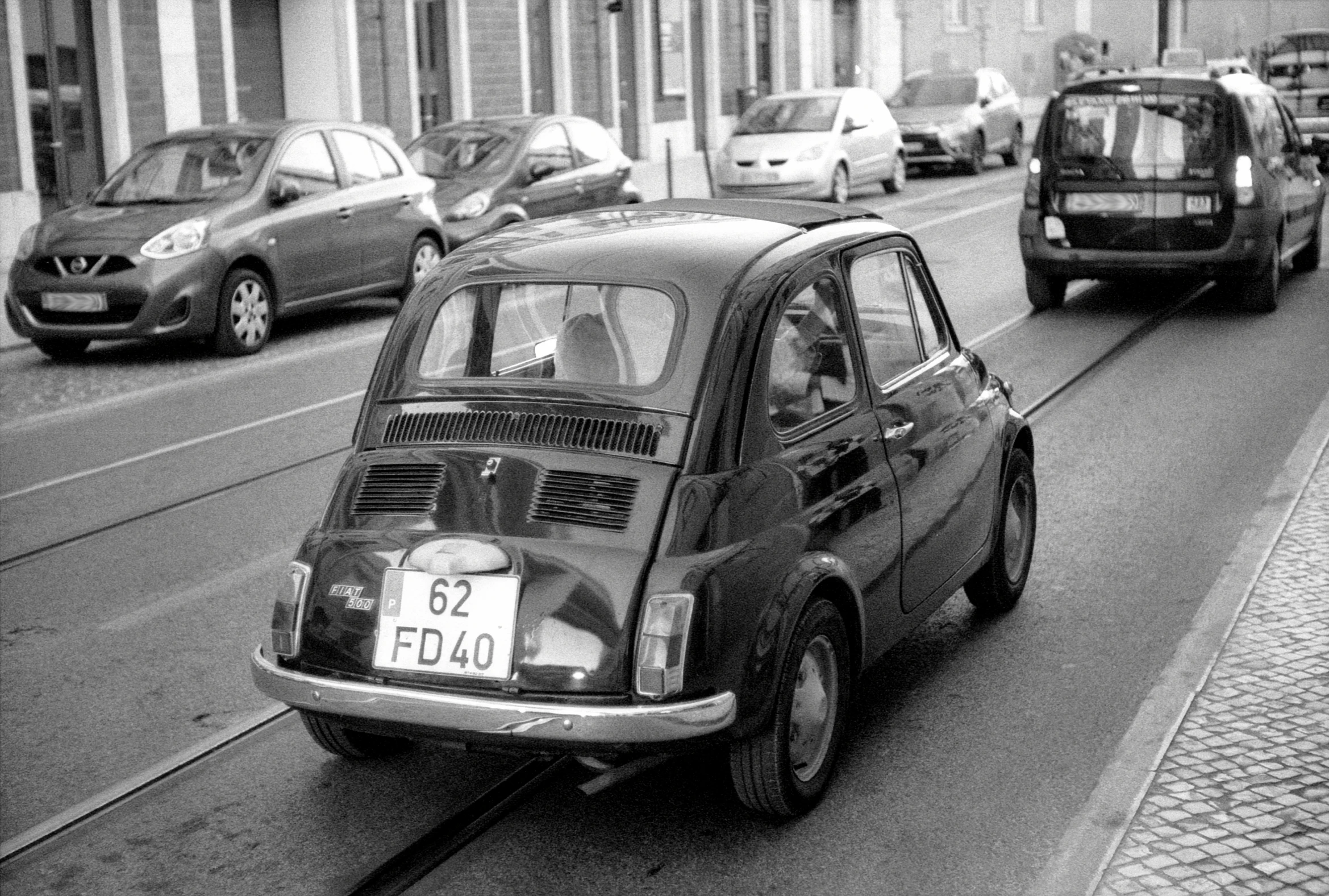 a small car driving down a city street