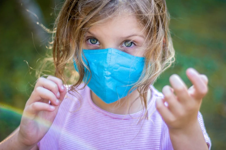 a  with blue face mask on in grassy field