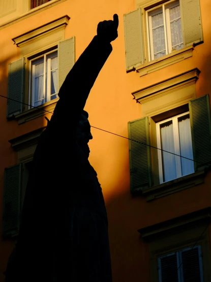 the statue stands next to a building with windows on it