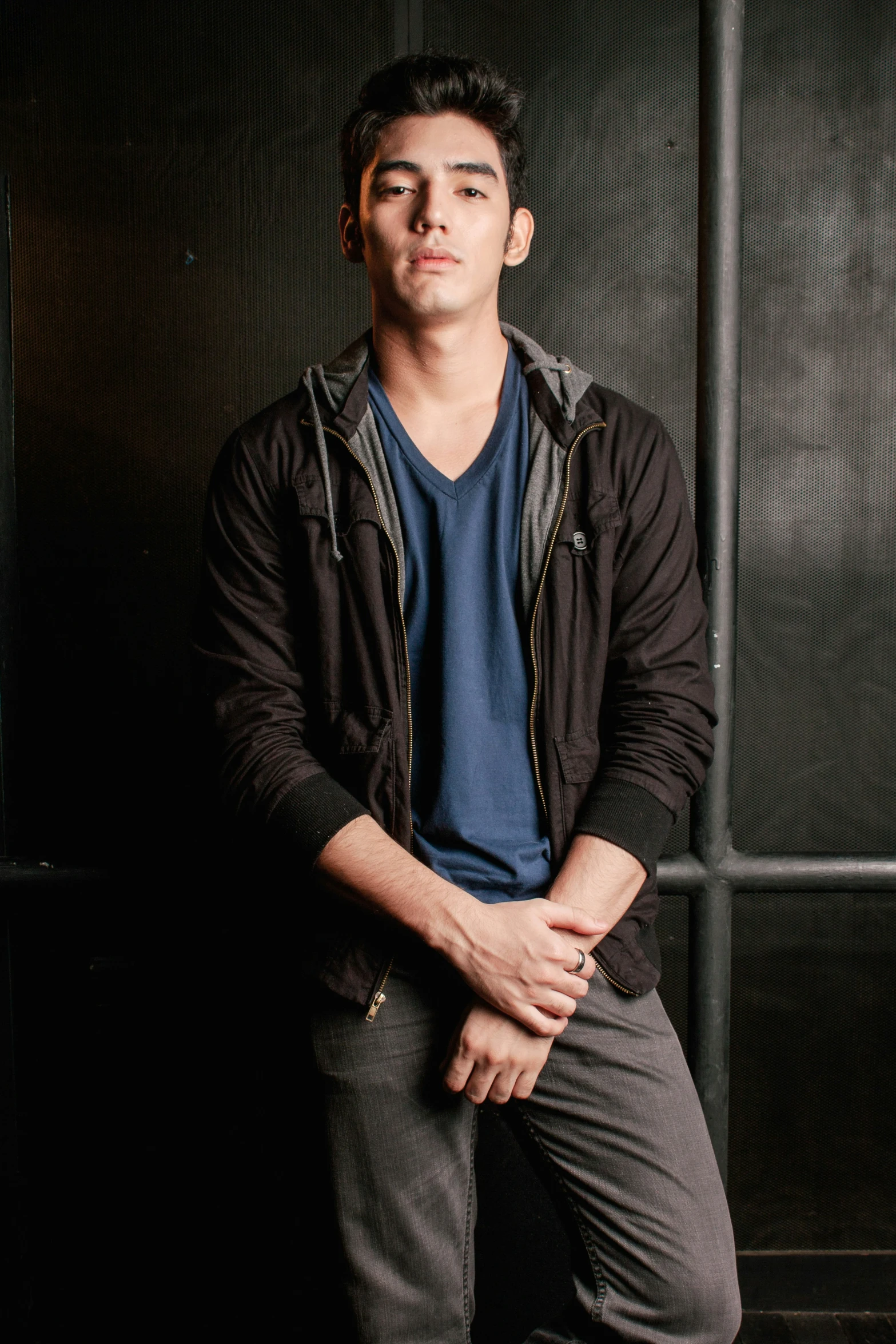 a young man in blue shirt sitting on a chair