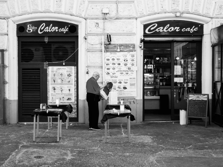 a man stands in front of the storefront