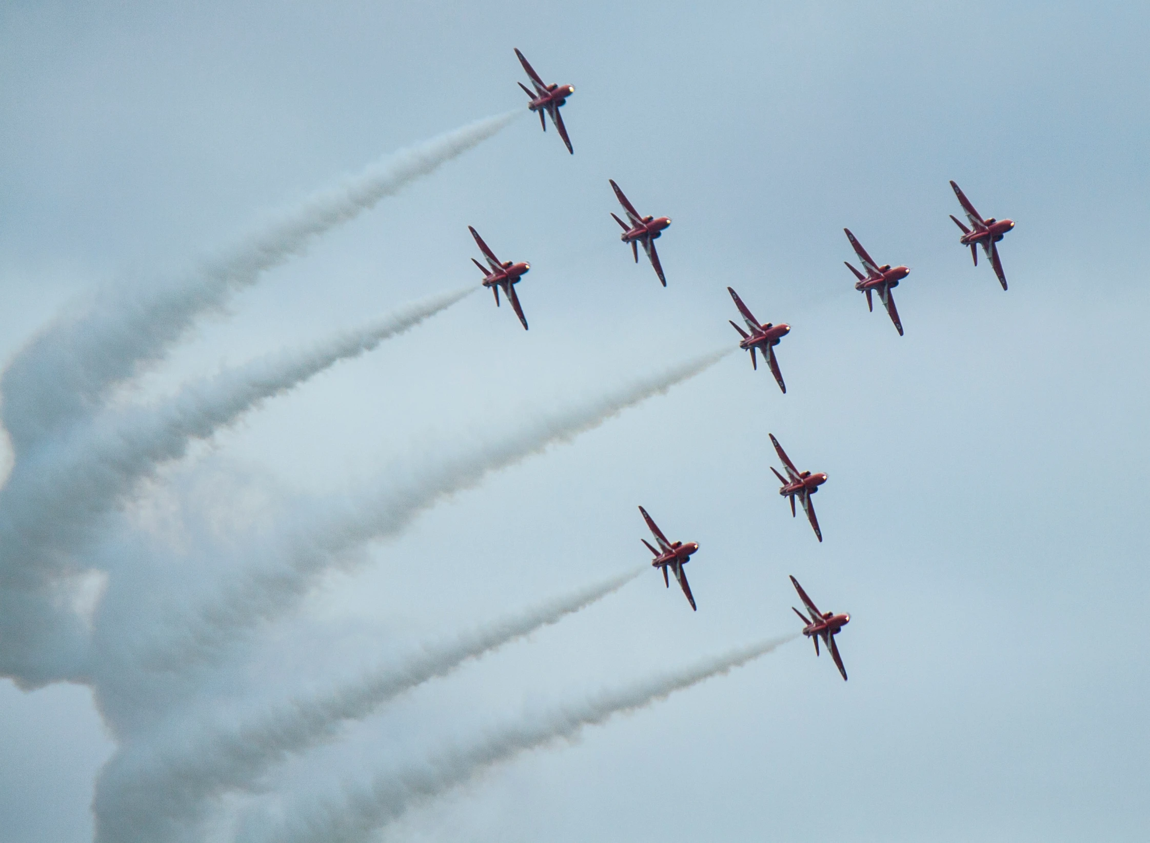 seven planes are flying in a sky leaving contrails behind