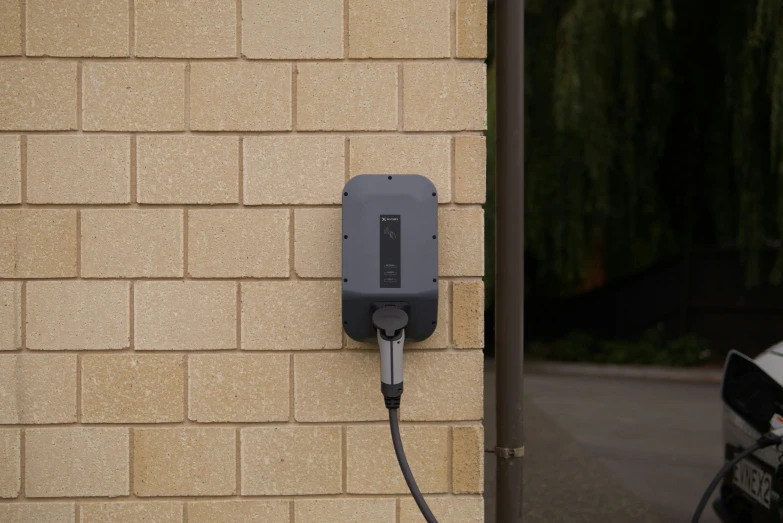 an electric car charger plugged into a brown wall