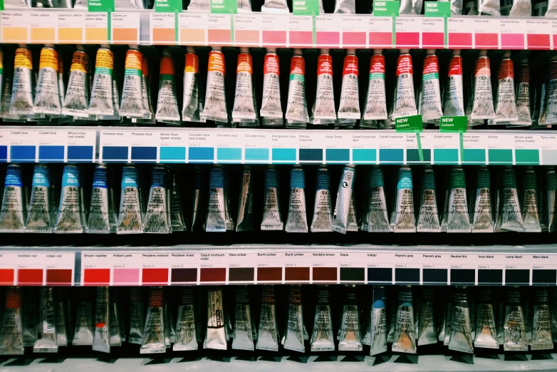 the shelf holds many different shades of paint