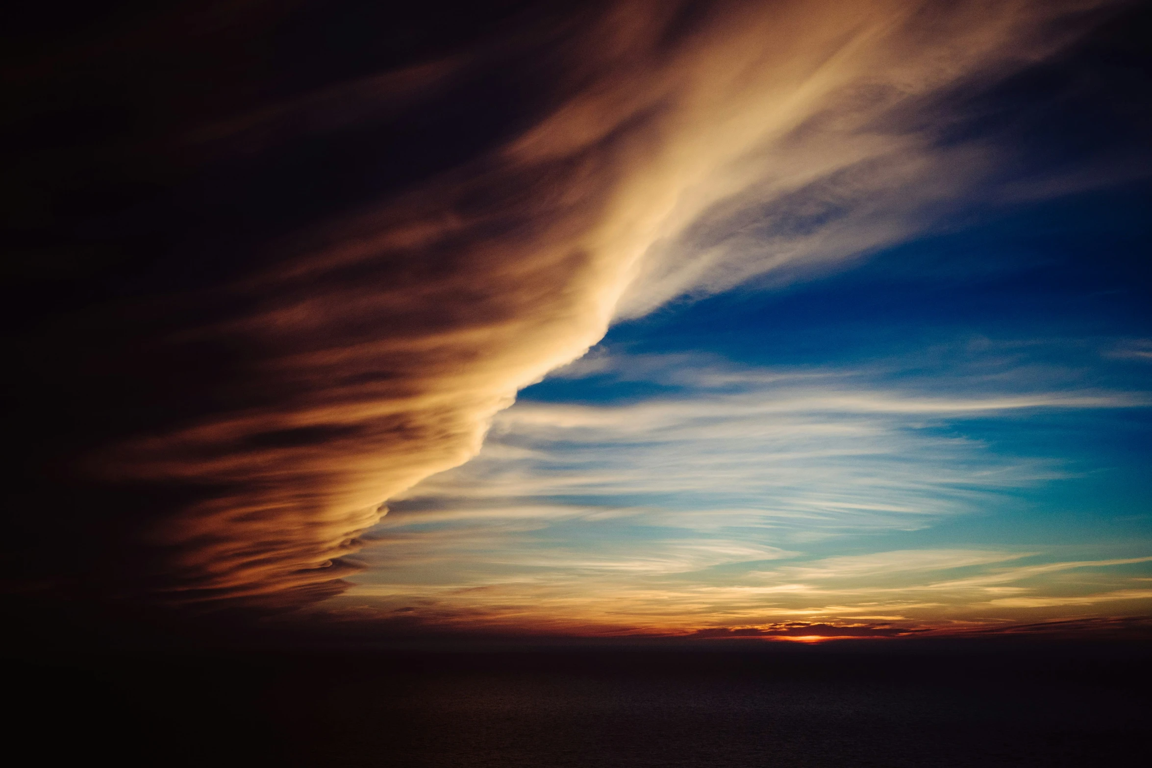 a group of clouds are above the ocean