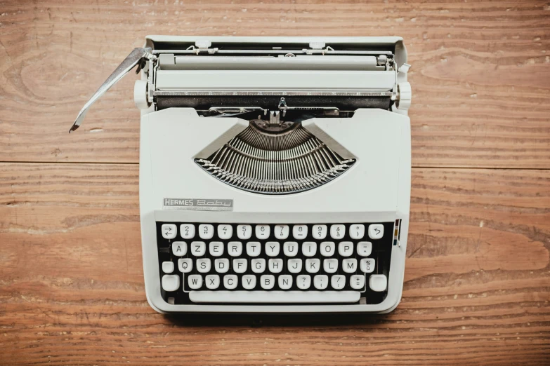 an old fashion white typewriter on wooden background
