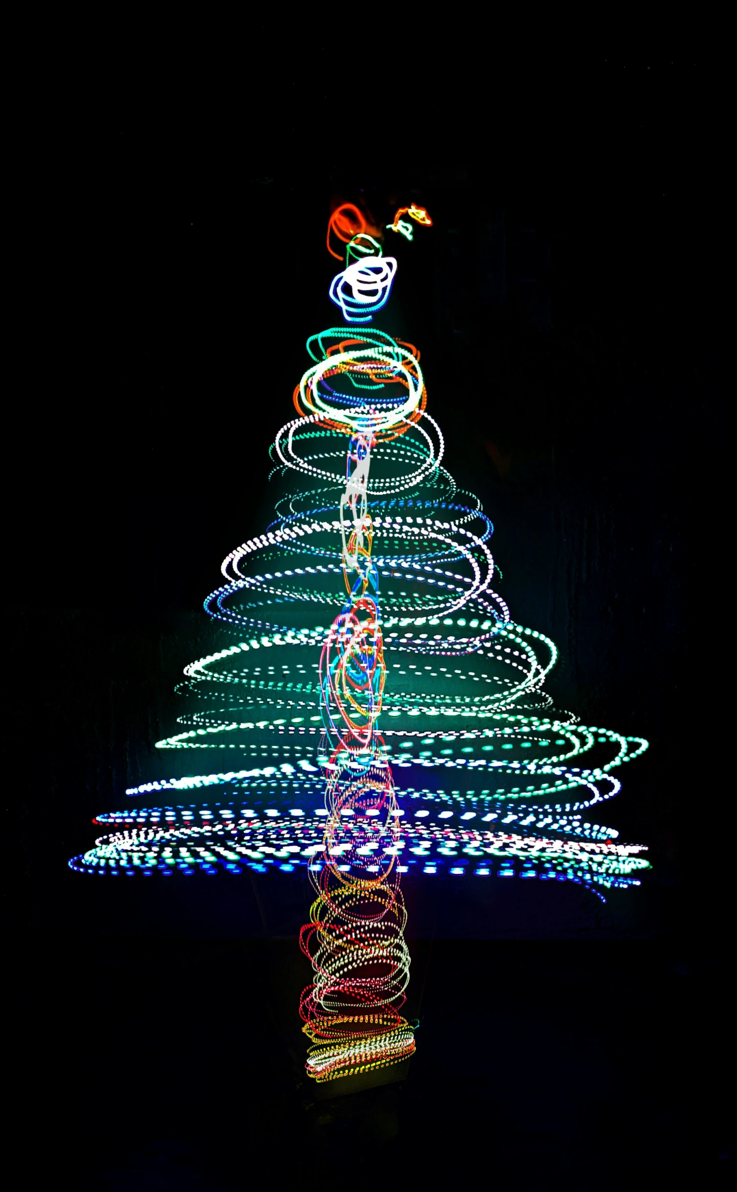 a christmas tree lit up at night with colored lights