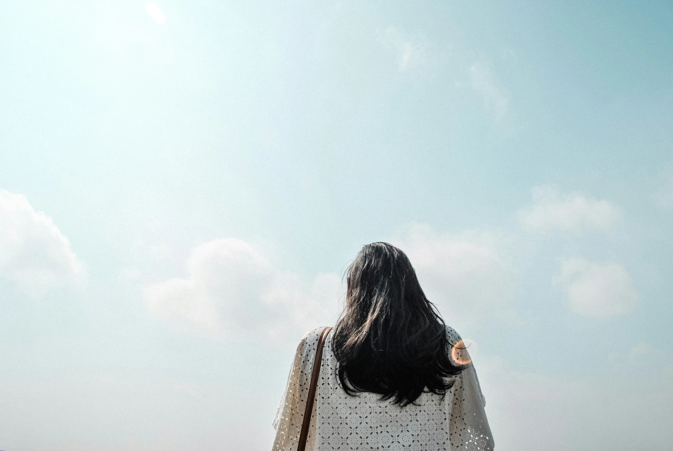 the back of a person's head and her jacket over her shoulders