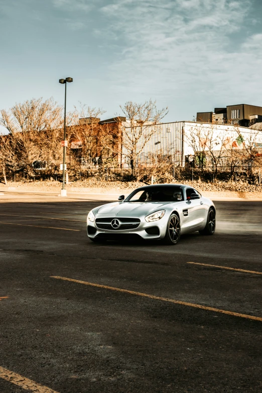 a mercedes benz sits parked in an empty parking lot