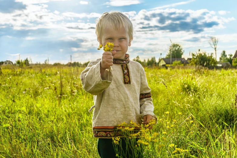 a little boy standing in a field of grass