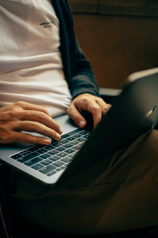 the person is working on their computer on the couch