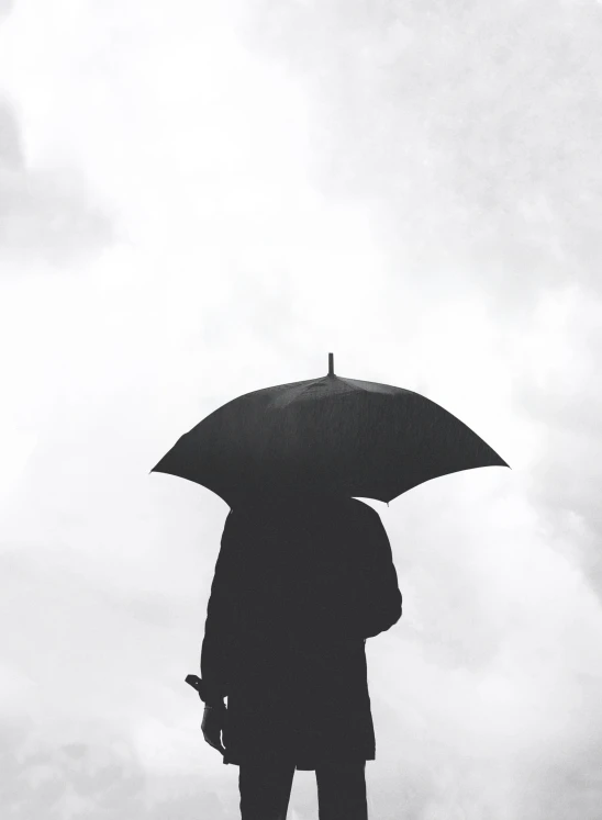 a person is holding an umbrella near some clouds