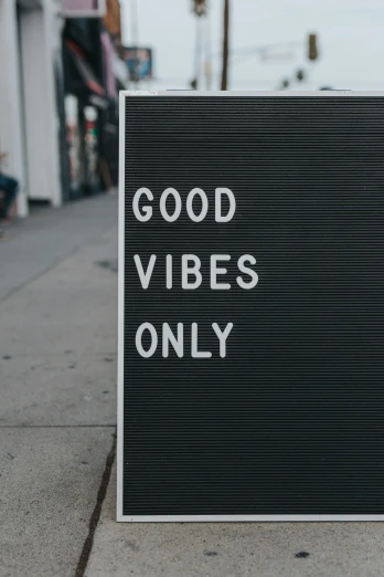 a sign that is on the sidewalk advertising good vibes only