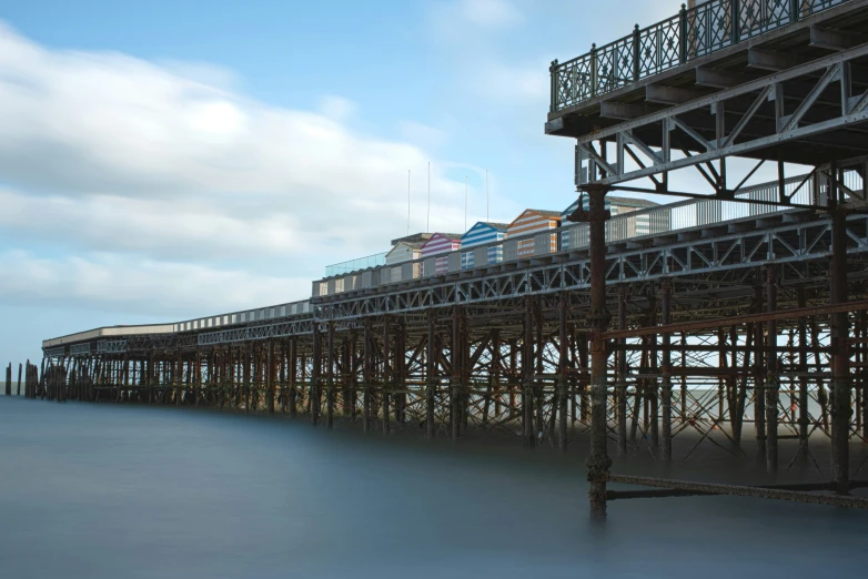 train and buildings on an elevated railway line in front of the ocean