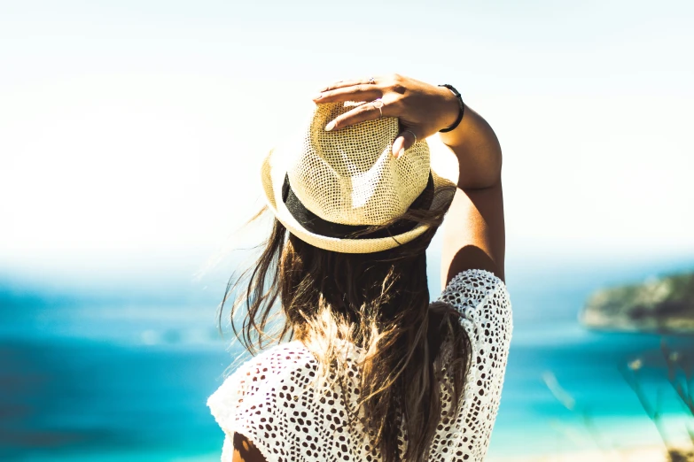 a person with long hair standing on the beach