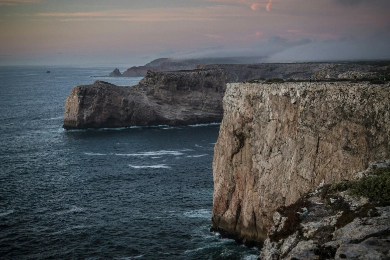 the edge of a cliff is shown with water