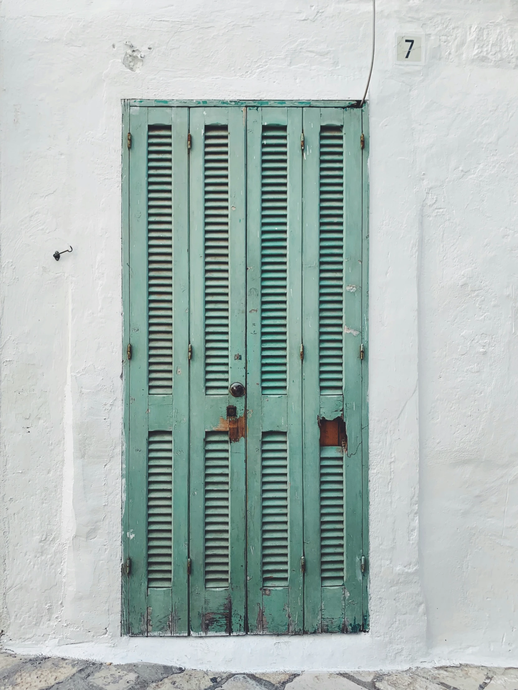 an old green doorway on a white building