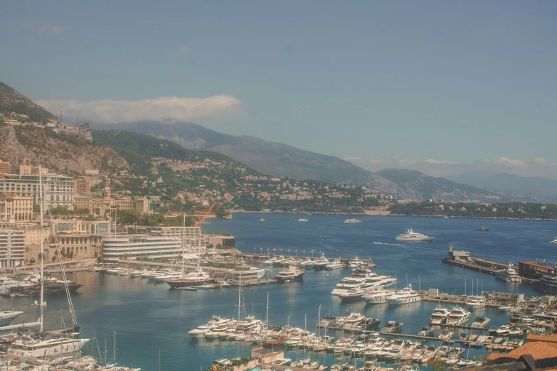 a city harbor with boats and mountains in the background