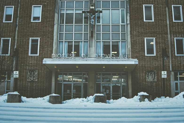 the snowy sidewalk outside of a brown brick building