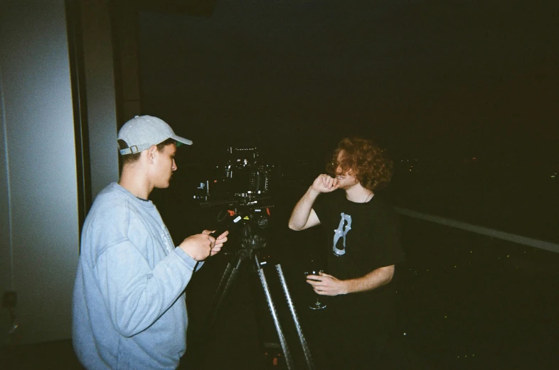 two men talking with a camera behind them