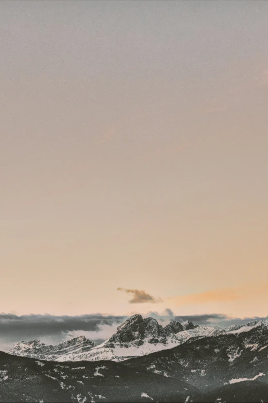 a person stands on top of a mountain, flying a kite