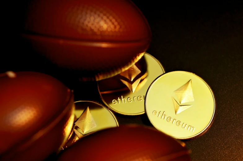 three shiny gold colored coins that are on top of a table