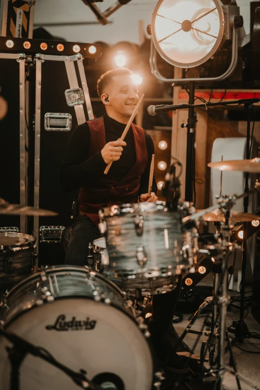 the young man plays drums in his music studio