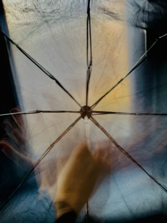 the underside of an umbrella in front of a person holding an umbrella