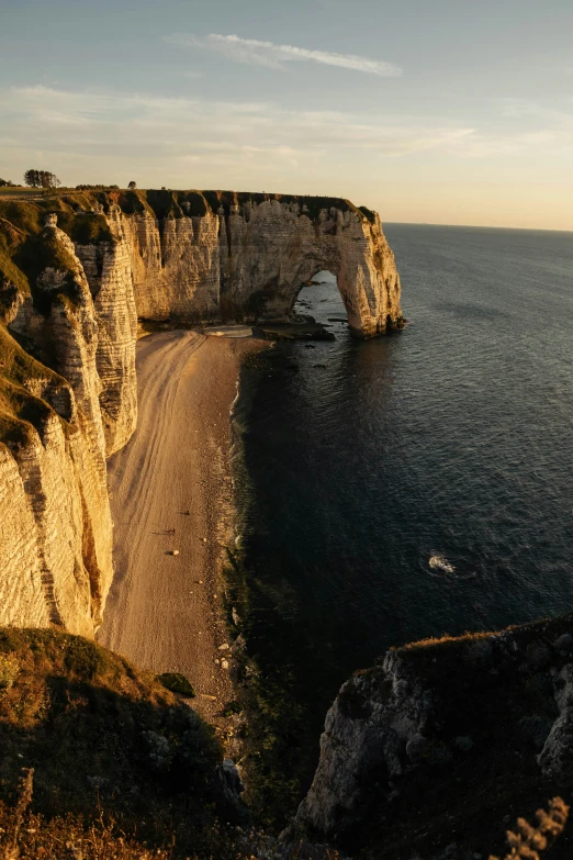 a cliff is shown at the edge of a body of water