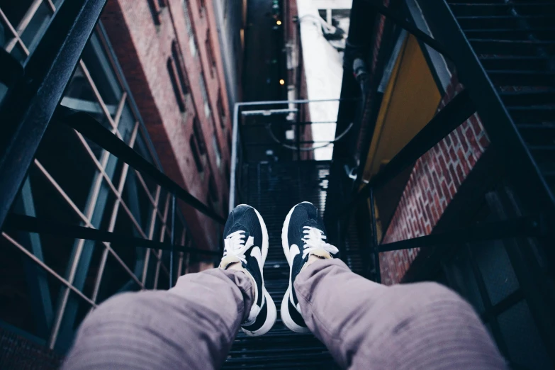 the person is walking down some stairs wearing sneakers