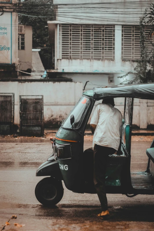 a man moving a small motorcycle on the street