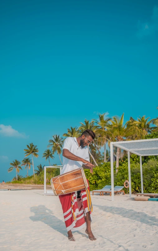 a man standing on the beach with several large items in his hand