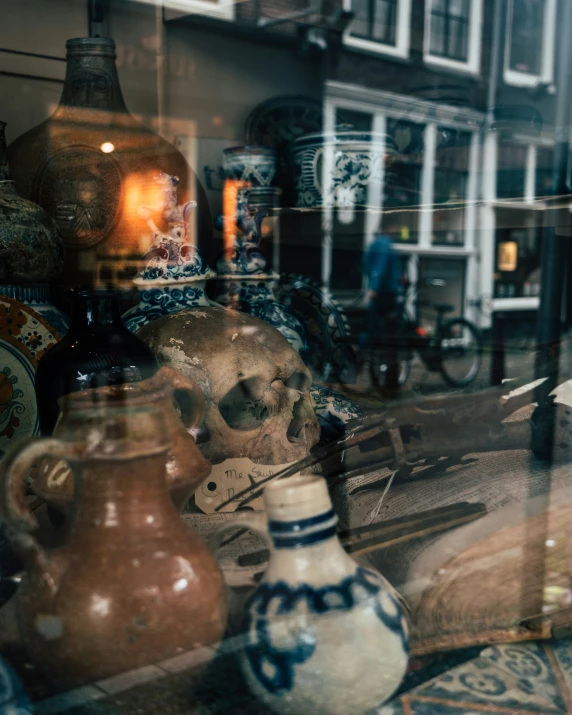 various decorative pots are behind glass in a store window