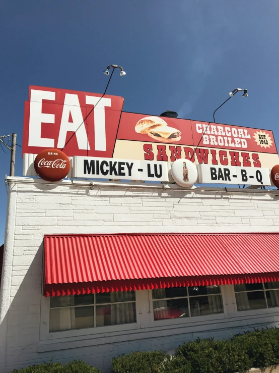 a restaurant with an eat sign and many signs