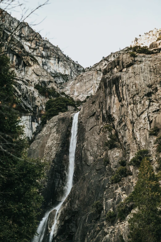 a waterfall is shown next to large mountains