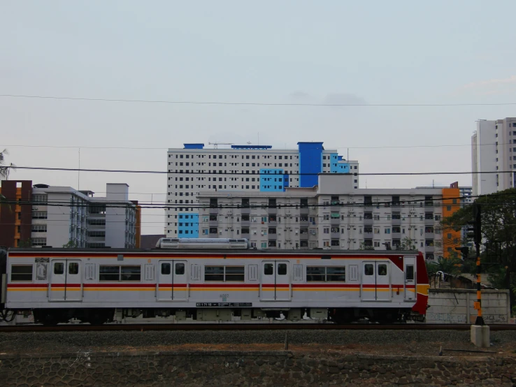 a train on some railroad tracks in front of tall buildings