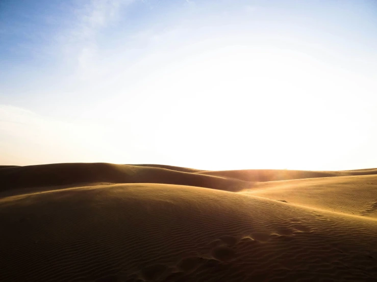 the sun is shining above a desert area