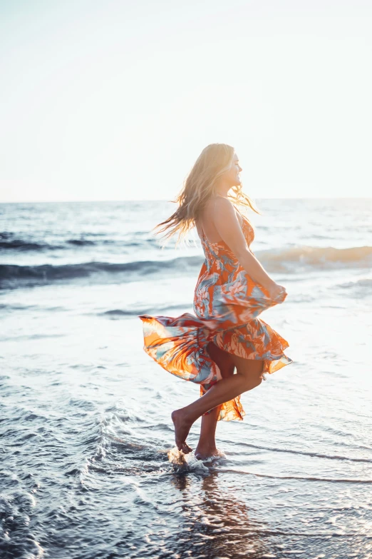 a girl on a beach holding a frisbee