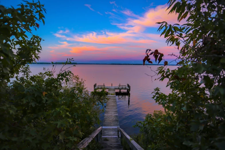 a pier at dusk next to a body of water