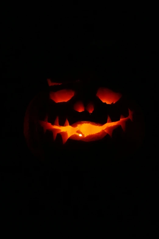 an illuminated pumpkin with a smile carved into it