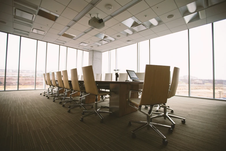 a long table with six chairs and laptop