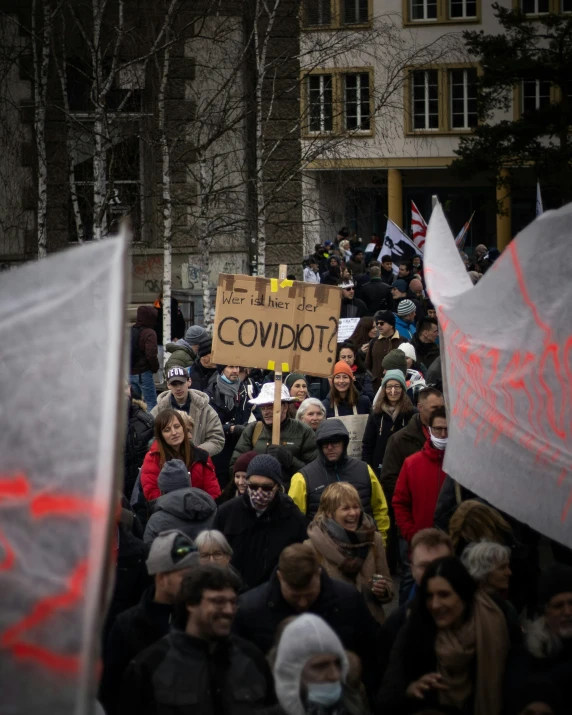 a crowd is standing outside and holding protest signs