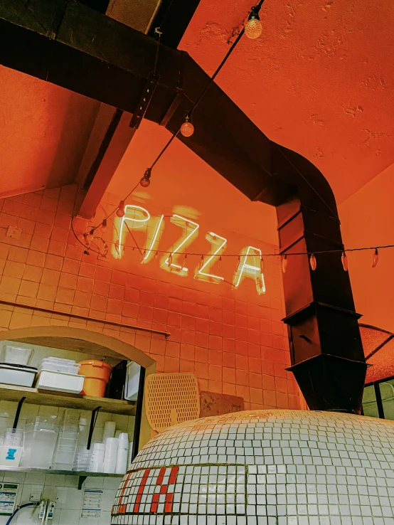 an orange glow of a clock and the word pizza