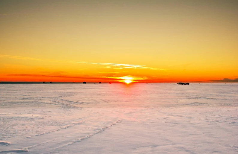 the sun is setting over an empty lake