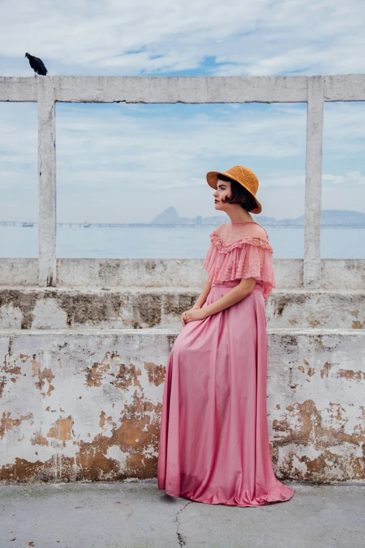 a woman is sitting down near an old wall