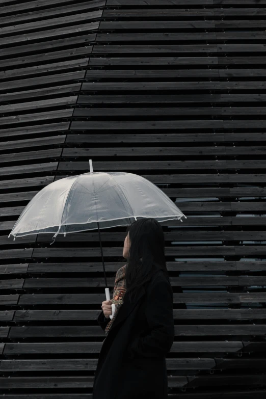 a woman is standing outside in the rain with an umbrella